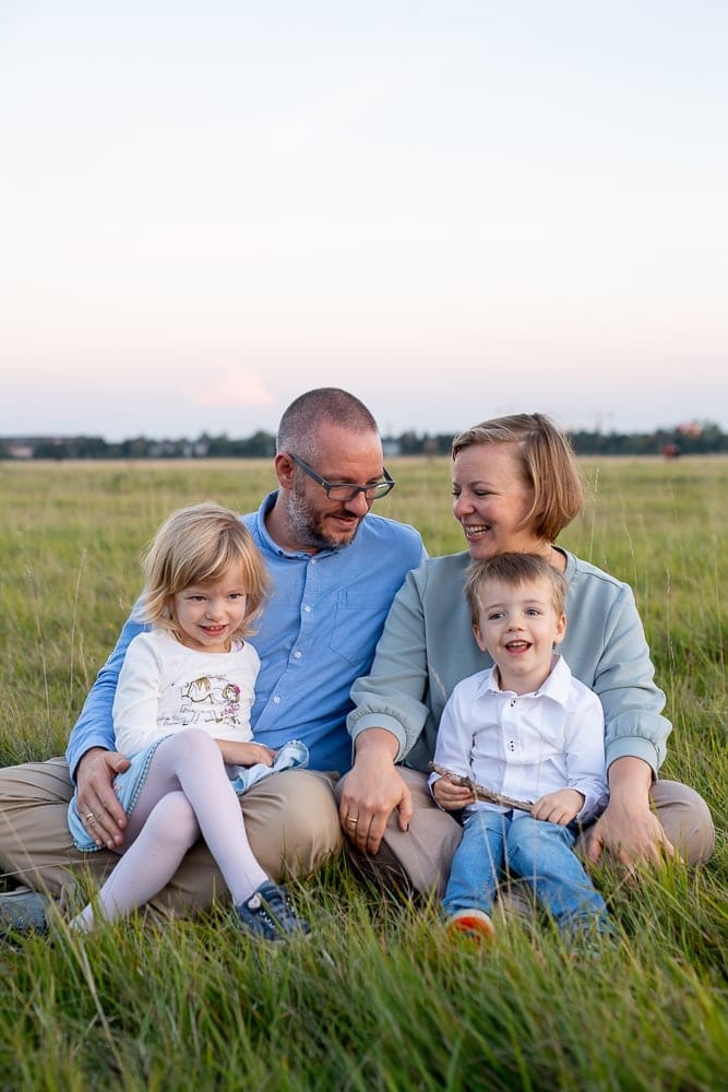 Porträt einer Familie im Grünen bei Sonnenuntergang, professionelle Familienfotografie in München, natürliche Fotos im Freien.