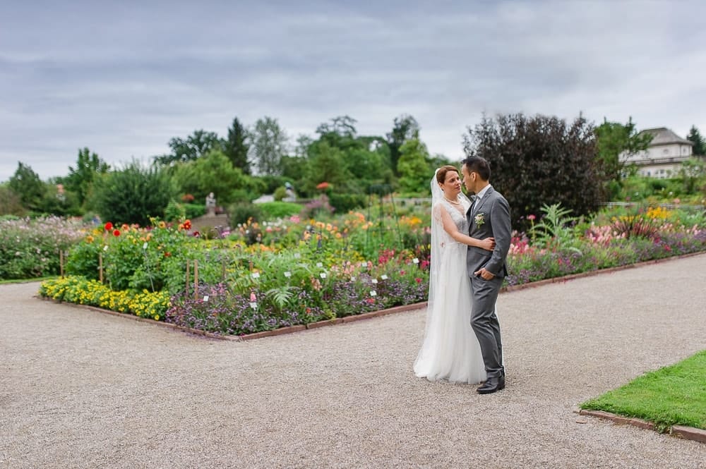 Naturbelassene Hochzeit im Münchner Garten – Romantisches Brautpaarshooting vor blühendem Blumenmeer.