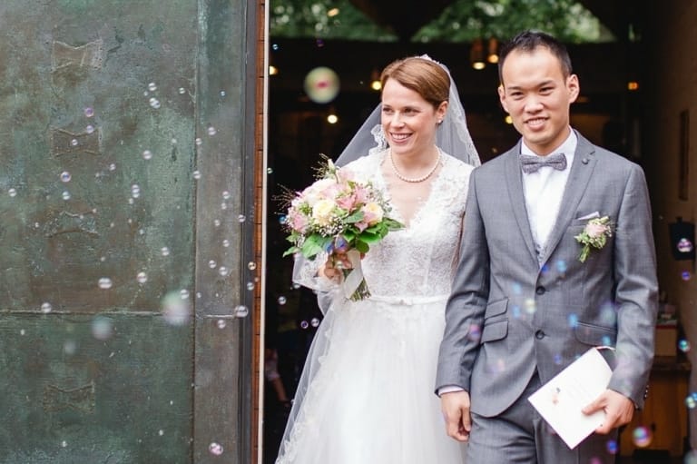 Glückliches Brautpaar bei Hochzeit im Fotostudio in München, professionelle Hochzeitsfotografie, kreative Porträtaufnahmen, Hochzeitsfotos vom Fachfotograf in München.