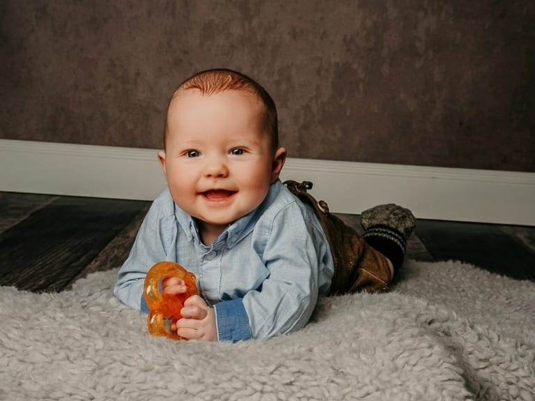 Helles Babyfoto im Münchner Fotostudio, professionell aufgenommen, mit weichem Teppich, freundlichem Baby, ideal für Familien- und Kinderfotografie.