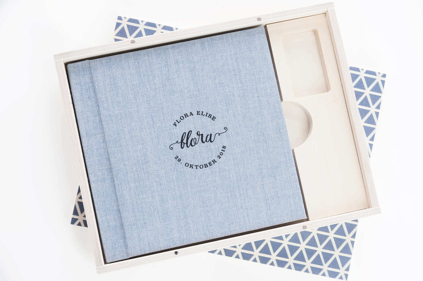 Hochzeitsalbum mit Text "Flora Elise Alora, 29. Oktober 2018" in einer weißen Holzbox, stilvoll und elegant.