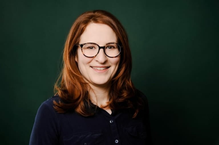 Hochwertiges Portrait einer jungen Frau mit Brille vor grünem Hintergrund bei Photogenika München, professionelles Fotoshooting, individuelle Portraitfotografie, studio München.