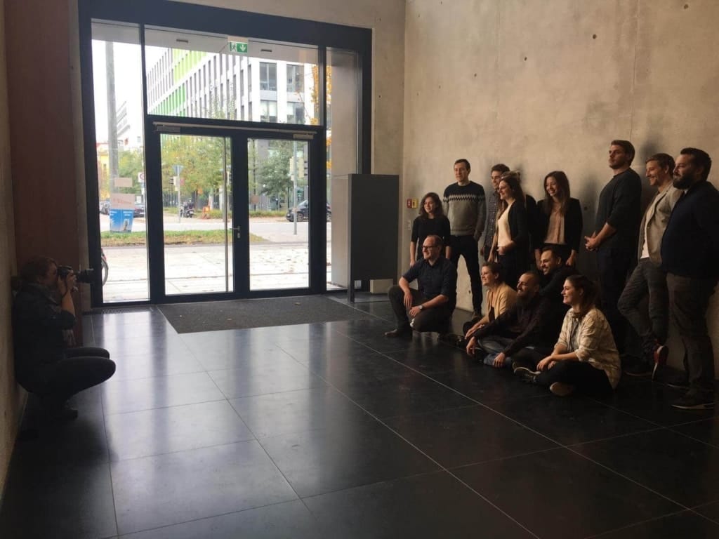 Menschen bei einem Gruppenfototermin im Fotostudio, professionelles Shooting in München. Fotografin macht Porträtaufnahme vor modernem urbanem Hintergrund. Perfektes Umfeld für professionelle Business- und Gruppenfotos.