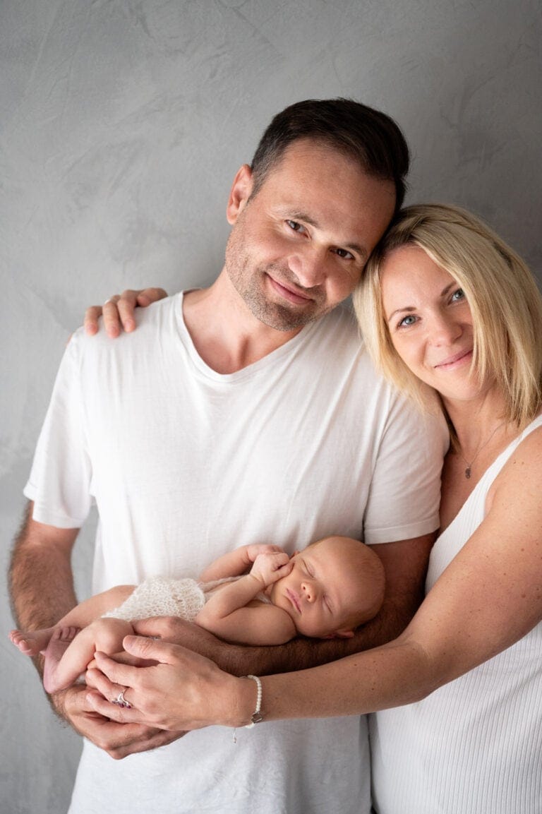 Family photo with newborn, happy parents holding baby, intimate family shot, baby photography, bright colors, emotional family moment.