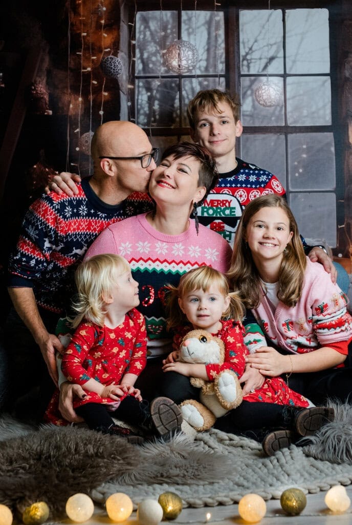 Familienfotografie im Weihnachtsstil bei Photogenika Fotostudio in München, festliche Stimmung, professionelle Weihnachtsfotos, Familienporträt, festliche Weihnachtskleidung, kreative Fotosession.