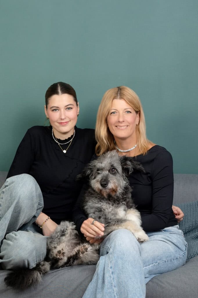 Happy family photo with mother, daughter and adorable dog, portrait in modern home setting, joyful mood, high quality, professional photography, Munich, Germany.