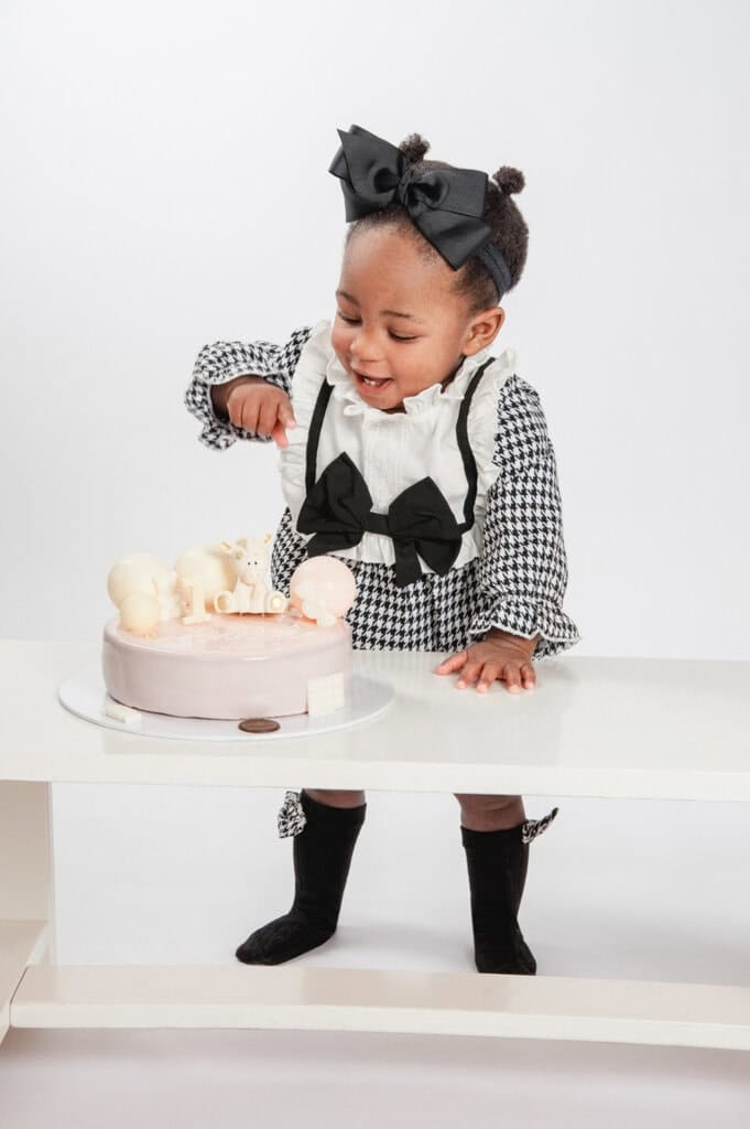 Kleinkind bestaunt seine Torte beim ersten Geburtstags-Fotoshooting.