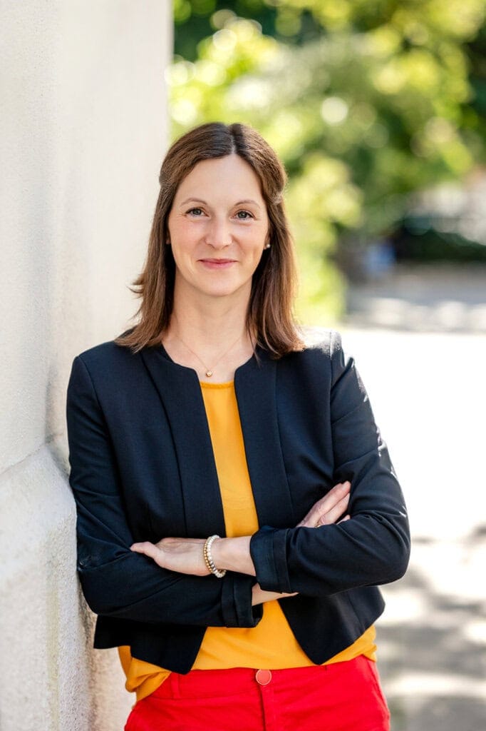 Frau in Business-Casual Kleidung mit gelbem Top im Freien.